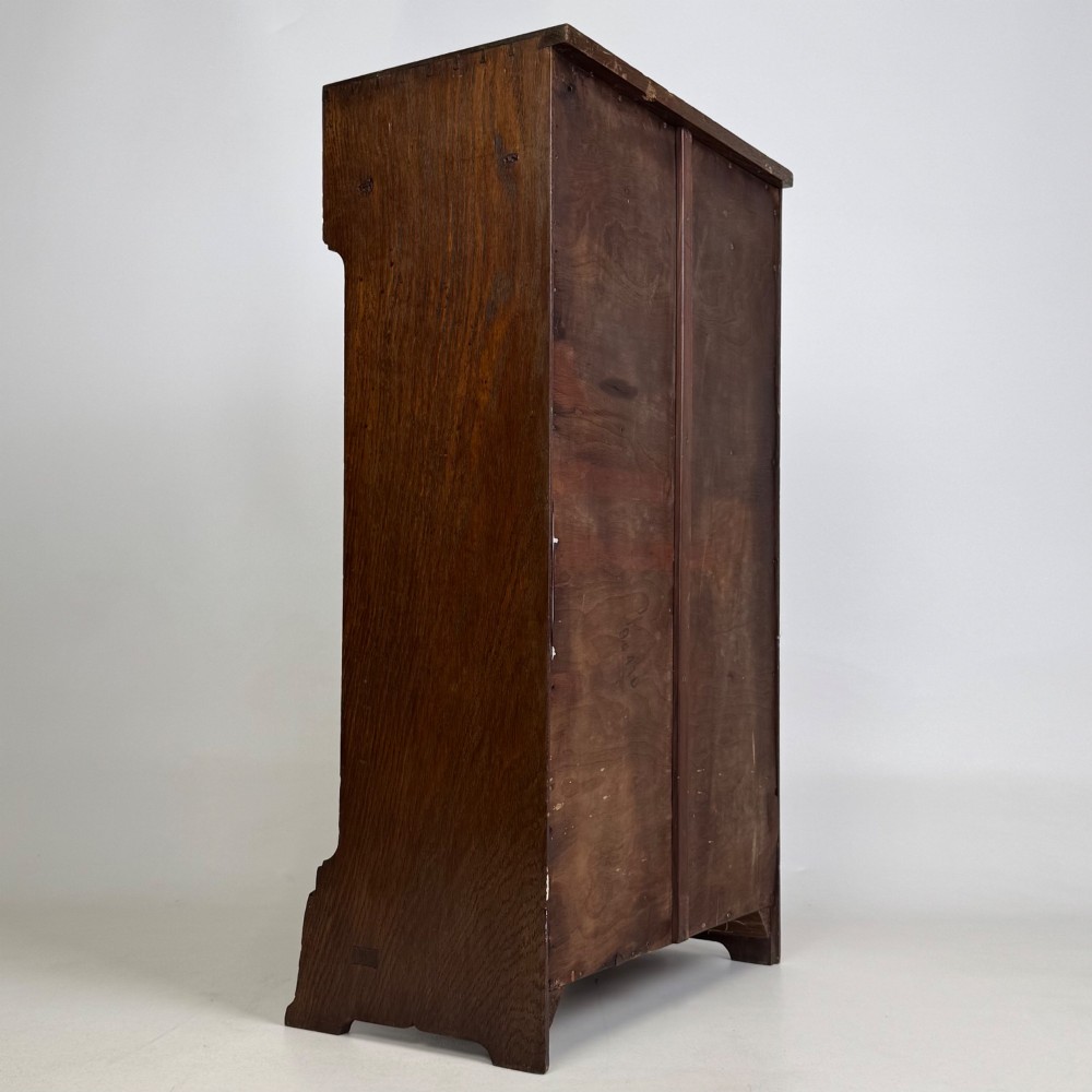 A small Edwardian open bookcase crafted from dark oak timber featuring three open shelves and a shaped apron base. View V