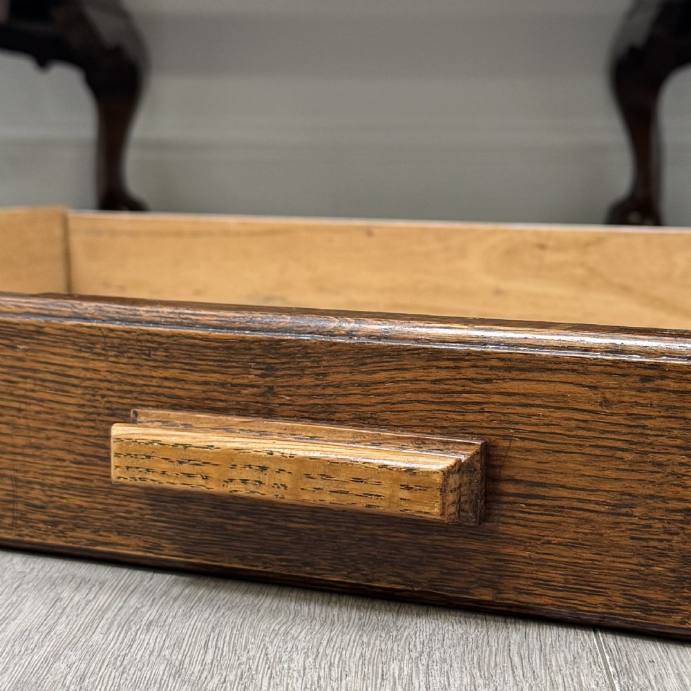 An antique oak pedestal desk featuring twin drawer pedestals, carved borders, and cabriole legs terminating in ball-and-claw feet. View XI