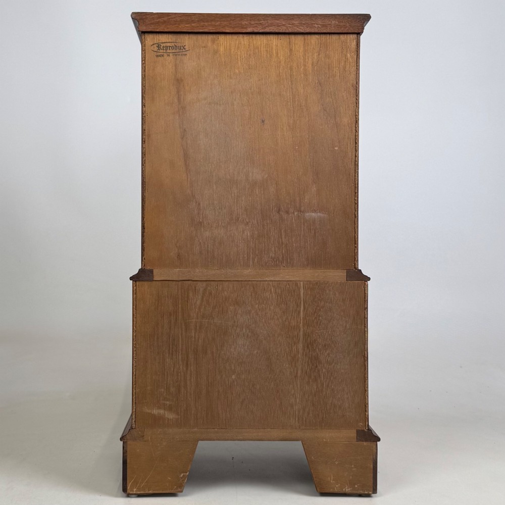 A small yew wood chest of drawers featuring a stepped tallboy structure with brass ring handles and bracket feet. View V