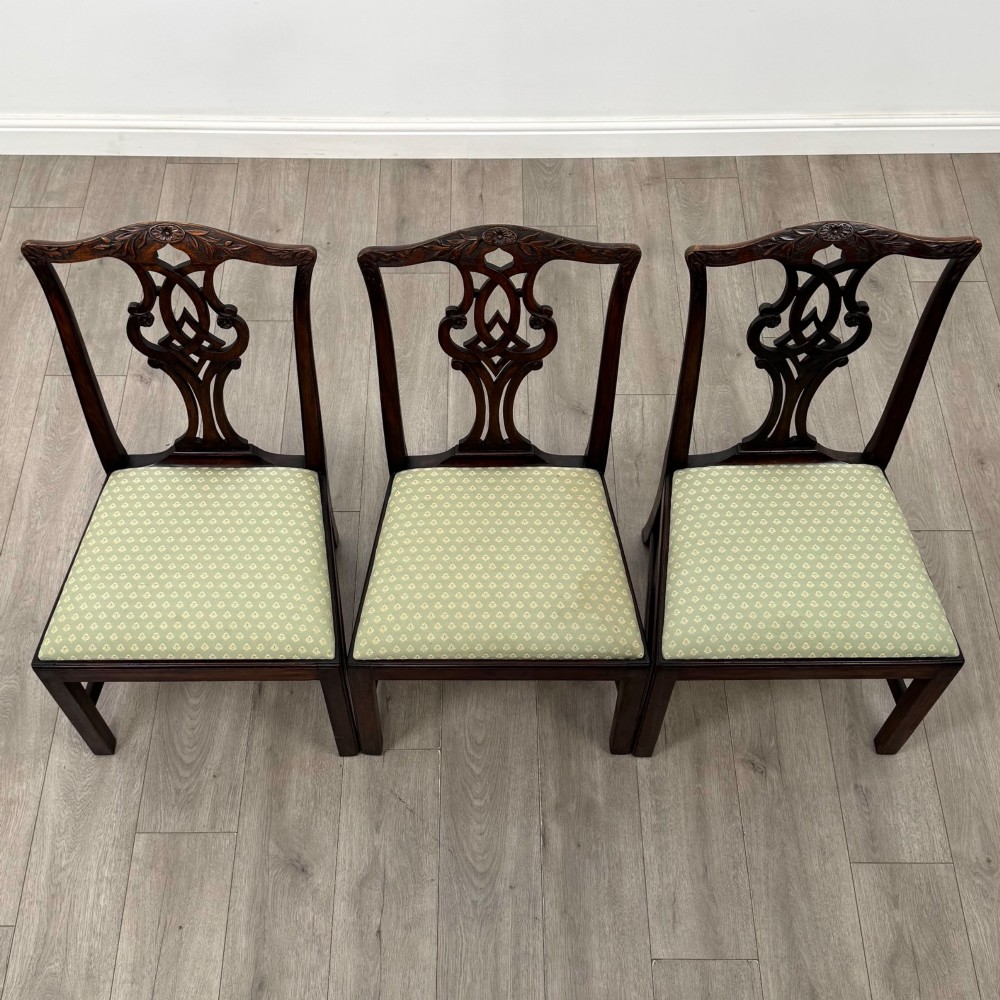 A set of six Georgian mahogany dining chairs featuring intricate carved pierced splat backs, square legs, and light green patterned upholstered seats. View VII