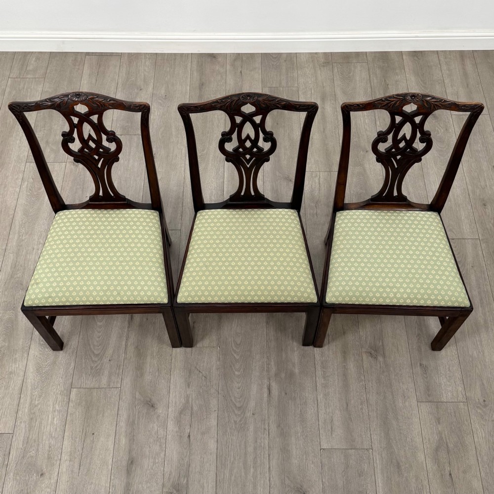 A set of six Georgian mahogany dining chairs featuring intricate carved pierced splat backs, square legs, and light green patterned upholstered seats. View VIII