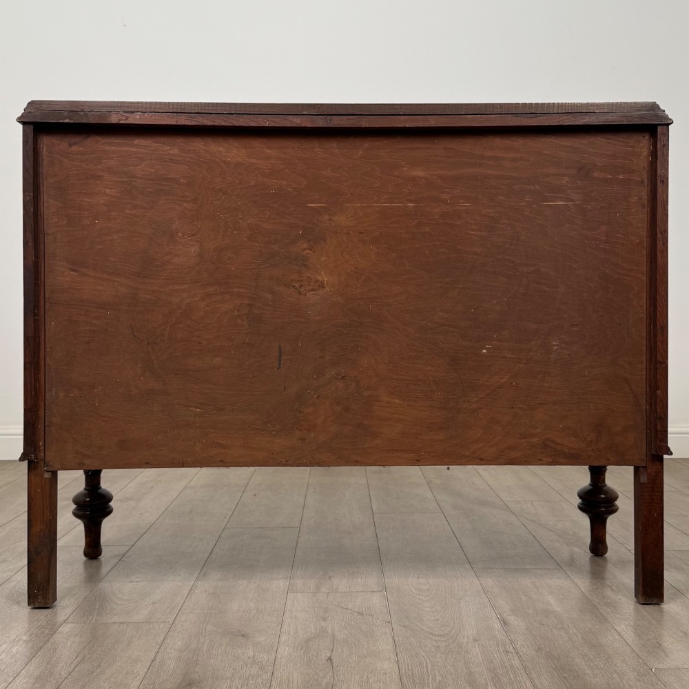 A dark oak sideboard featuring two carved drawers above a double-door cupboard resting on turned legs. View VI