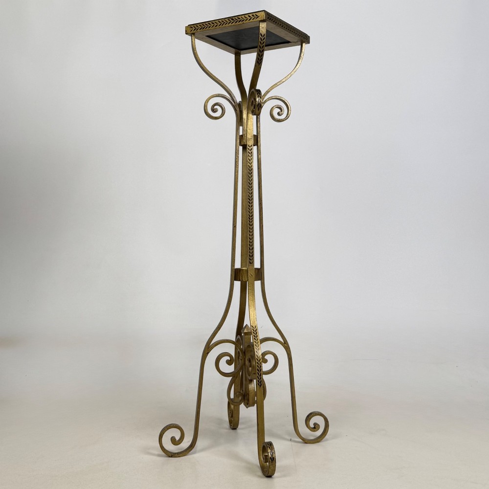 A pair of tall gilded metal plant stands featuring incised leaf patterning, scrollwork legs, and square dark marble tops. View V