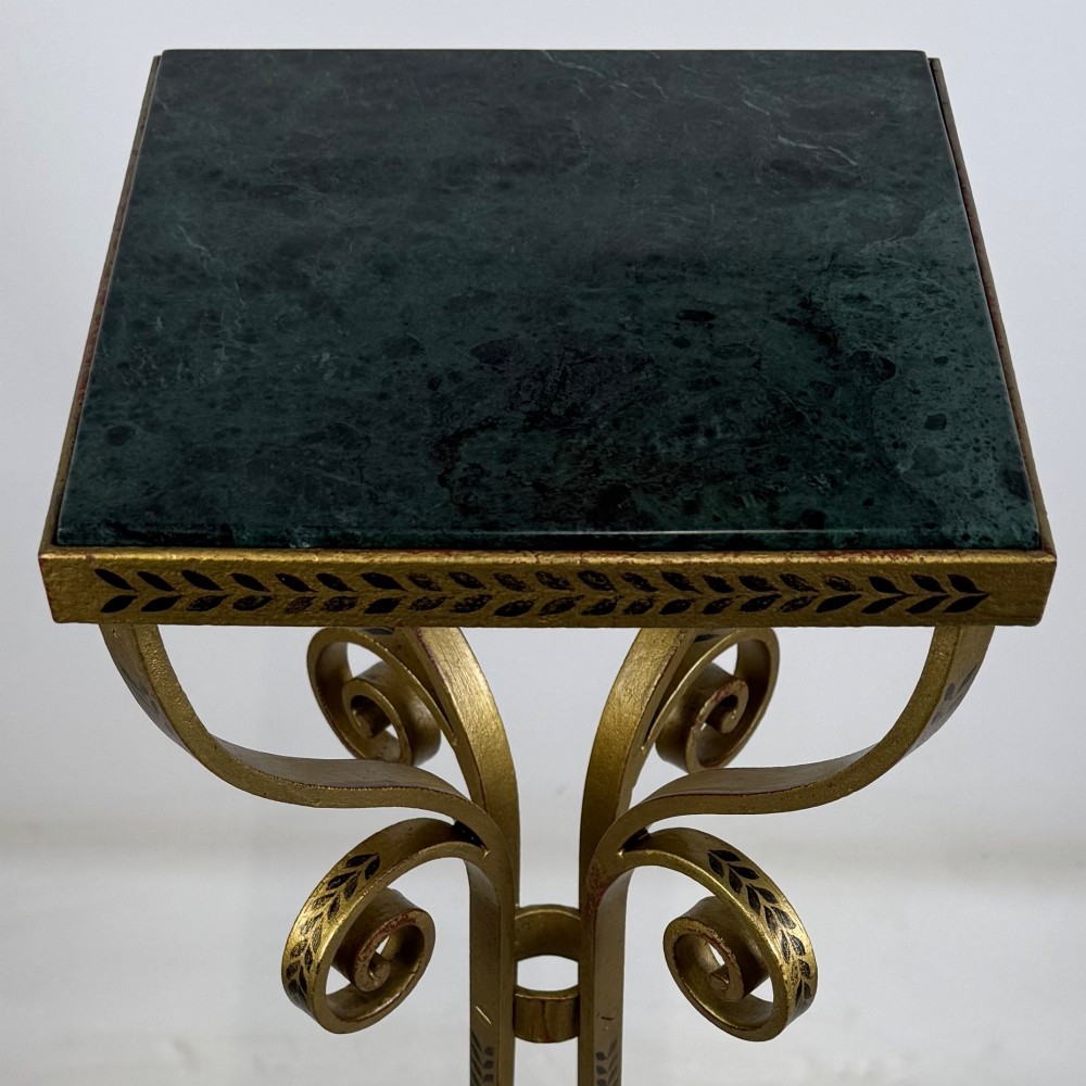 A pair of tall gilded metal plant stands featuring incised leaf patterning, scrollwork legs, and square dark marble tops. View IX
