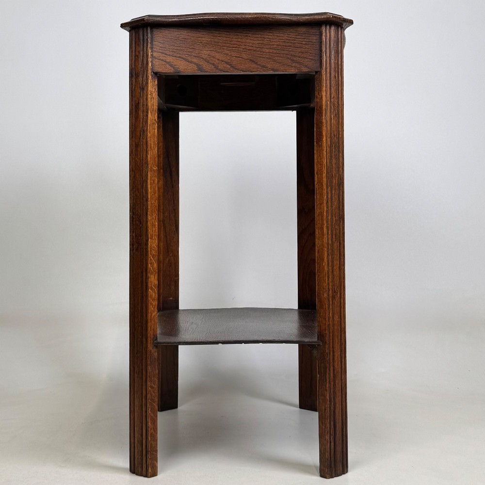 An Edwardian dark oak side table featuring fluted legs, a moulded top, and a lower shelf tier. View III