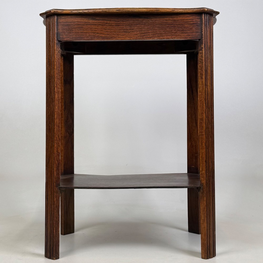 An Edwardian dark oak side table featuring fluted legs, a moulded top, and a lower shelf tier. View V