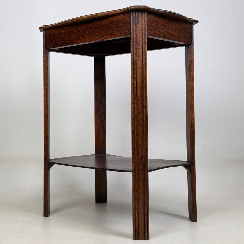 An Edwardian dark oak side table featuring fluted legs, a moulded top, and a lower shelf tier. View VI