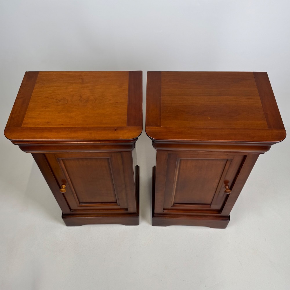 A matching pair of 20th-century mahogany bedside cabinets featuring single panelled doors, turned wooden handles, moulded cornices, and solid plinth bases. View XI