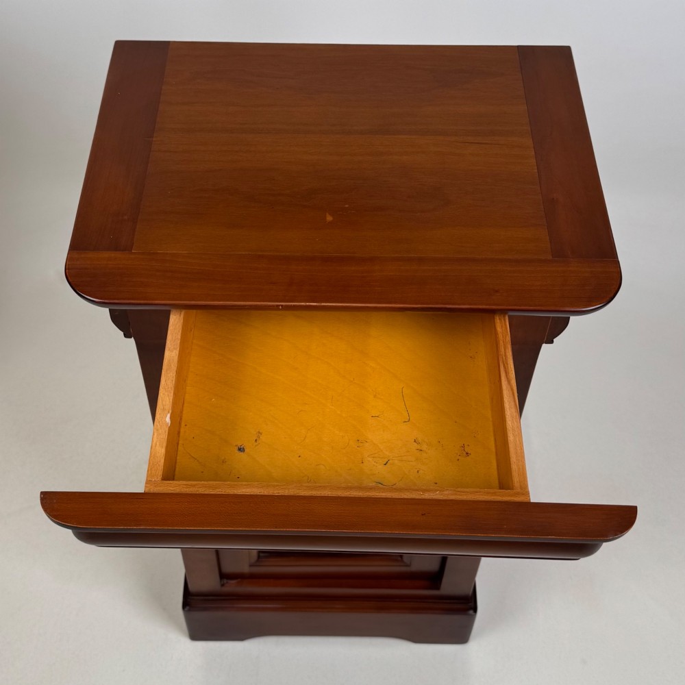 A matching pair of 20th-century mahogany bedside cabinets featuring single panelled doors, turned wooden handles, moulded cornices, and solid plinth bases. View XII