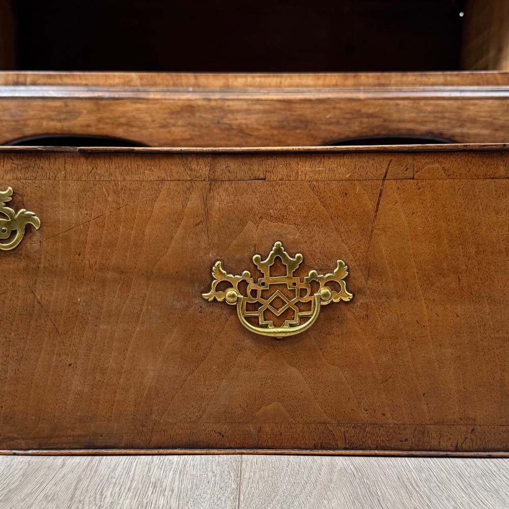 An antique 19th-century William and Mary style walnut chest of drawers featuring two deep drawers with ornate brass drop handles, raised on turned legs connected by a wavy stretcher base. View XI