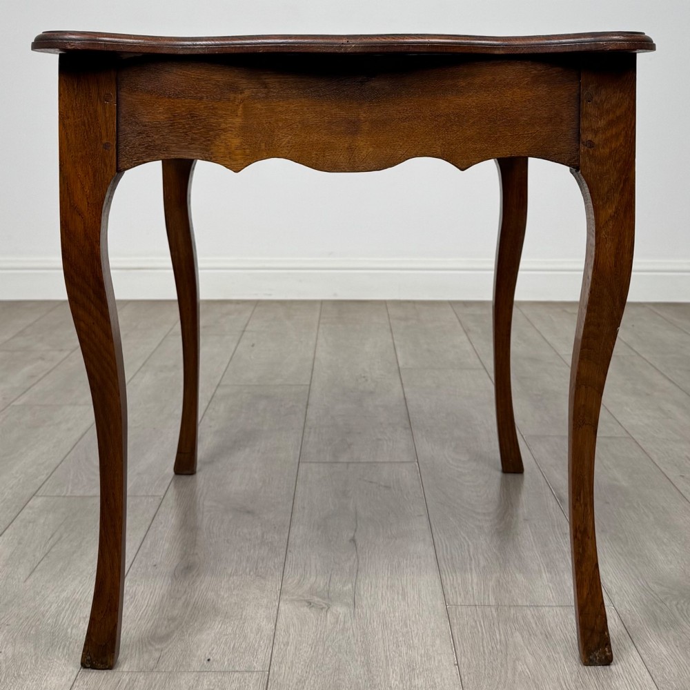 A French provincial oak side table with curved cabriole legs and a scalloped apron. View III