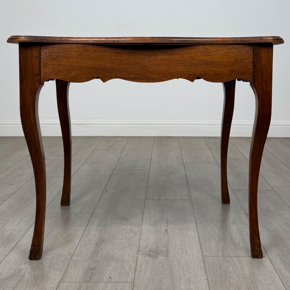 A French provincial oak side table with curved cabriole legs and a scalloped apron. View V