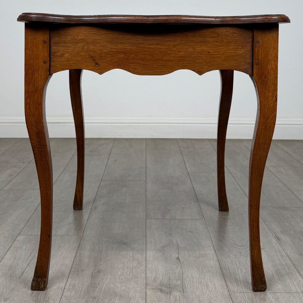 A French provincial oak side table with curved cabriole legs and a scalloped apron. View VII