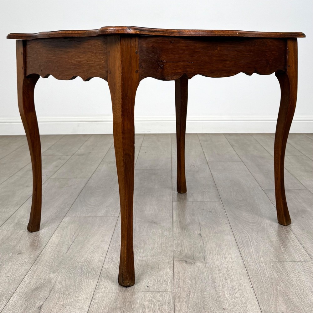 A French provincial oak side table with curved cabriole legs and a scalloped apron. View VIII