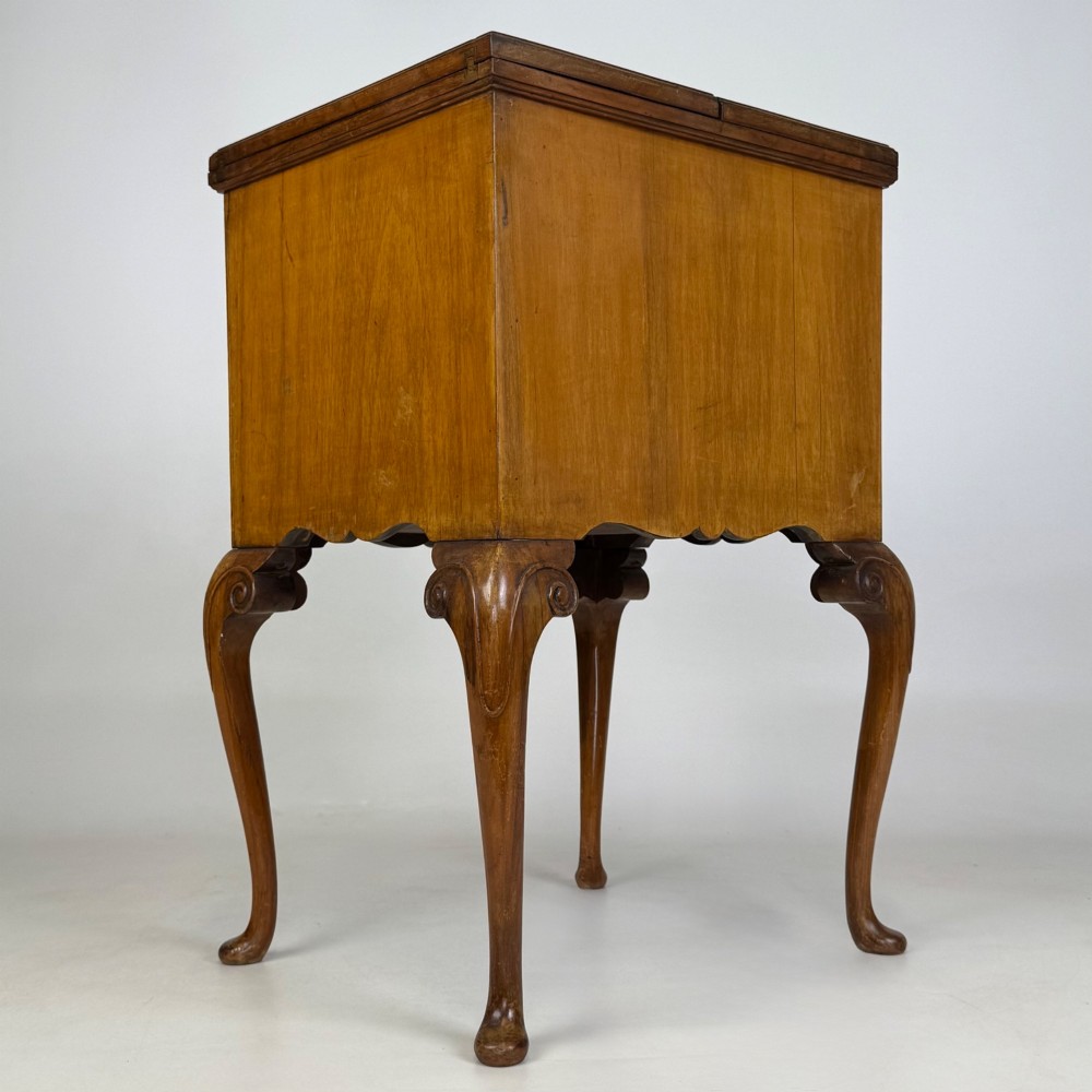 An Edwardian burr walnut cabinet resting on slender cabriole legs with ornate brass drop handles. View IV