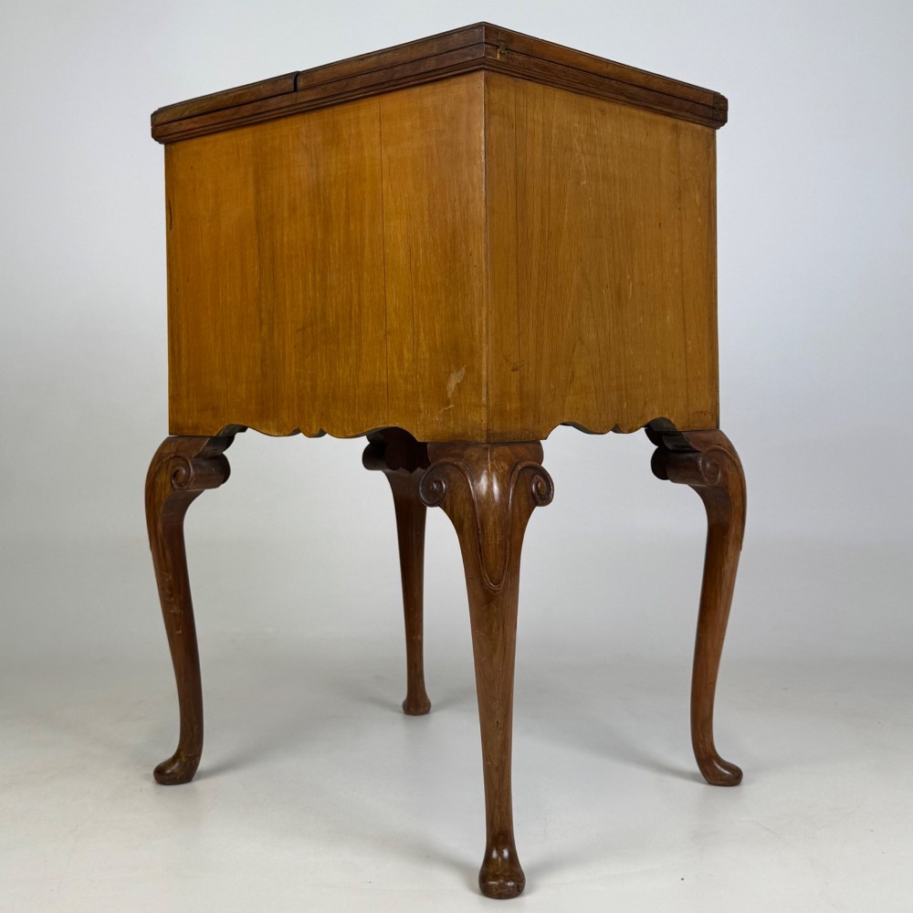 An Edwardian burr walnut cabinet resting on slender cabriole legs with ornate brass drop handles. View VI
