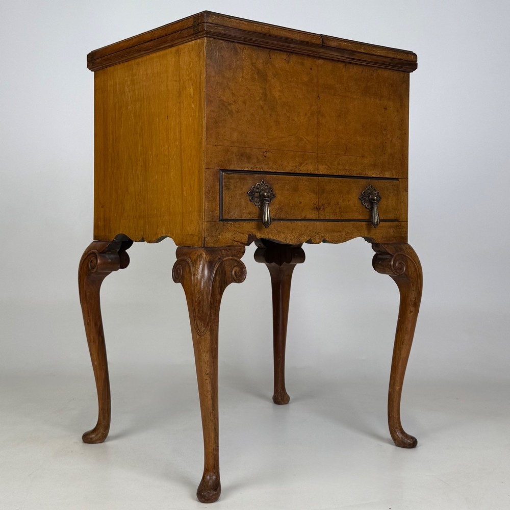 An Edwardian burr walnut cabinet resting on slender cabriole legs with ornate brass drop handles. View VIII