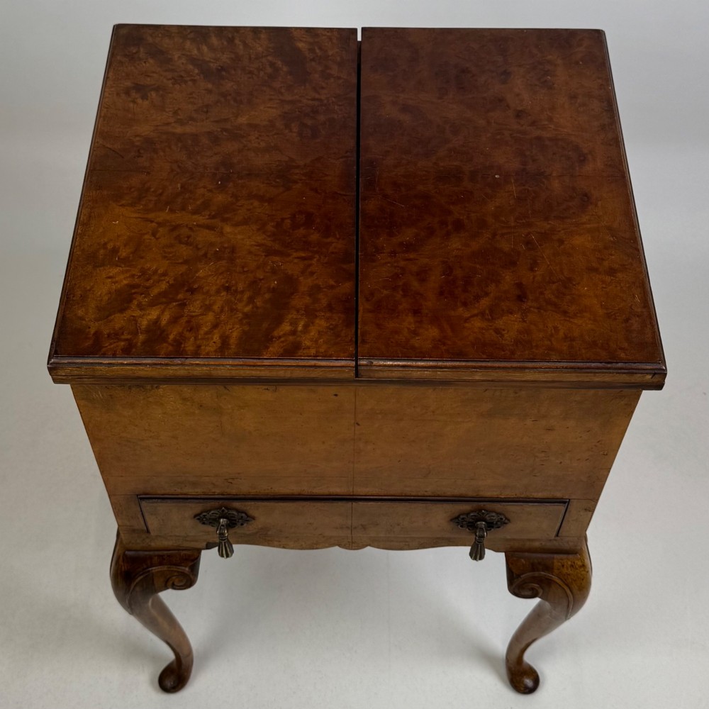 An Edwardian burr walnut cabinet resting on slender cabriole legs with ornate brass drop handles. View X