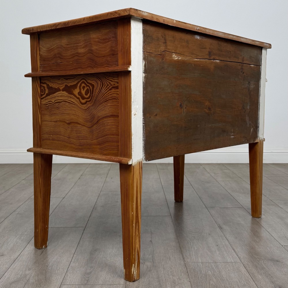 A Victorian pitch pine cupboard featuring a single top drawer over two cupboard doors with diagonal timber panels and straight tapered legs. View V