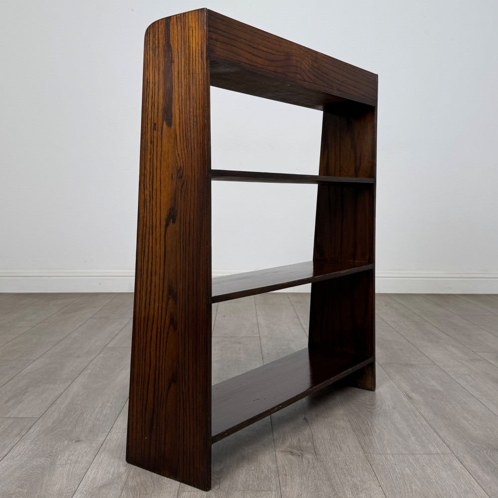 A dark oak Edwardian open bookcase with four horizontal shelves holding leather-bound books. View V