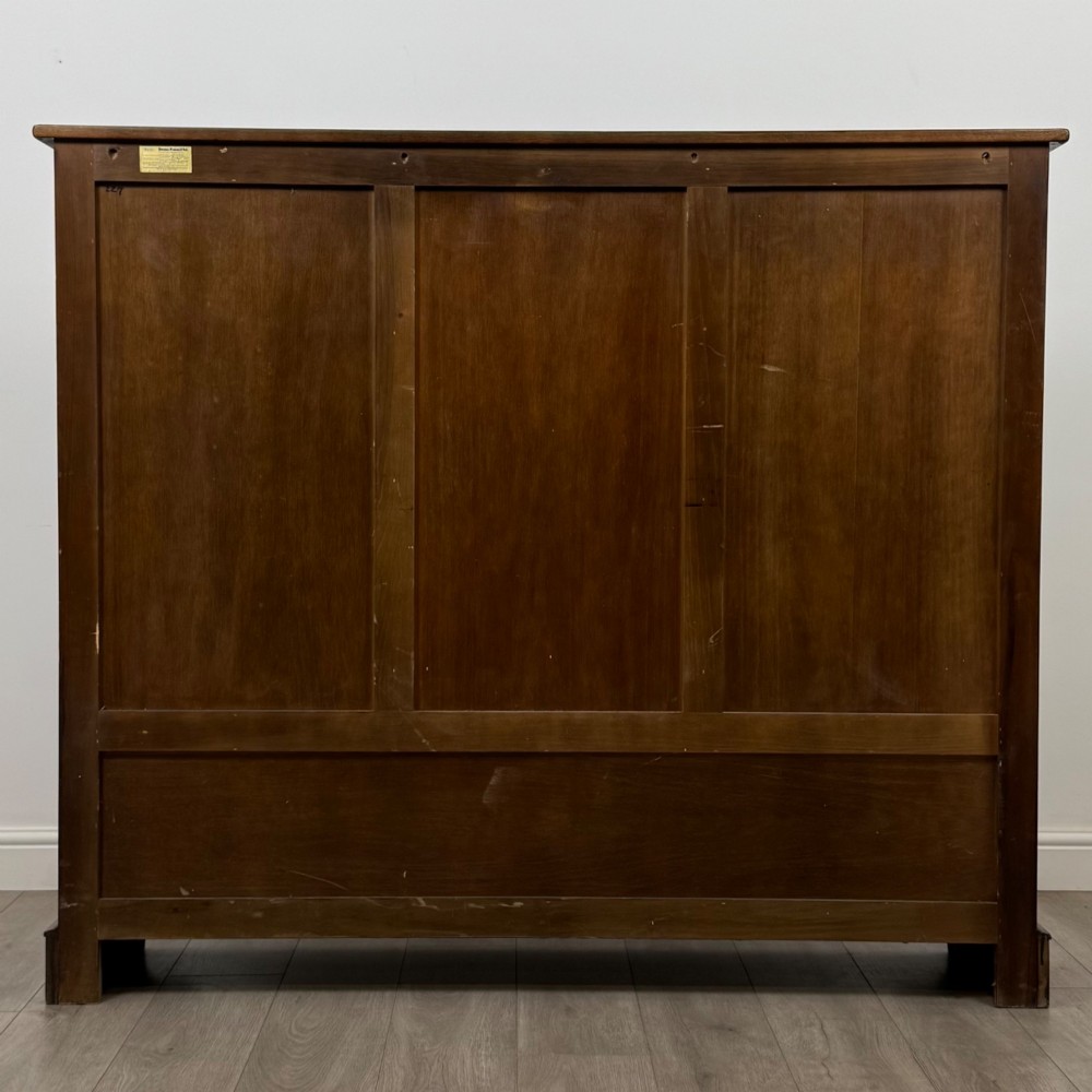 A large dark brown carved oak display cabinet featuring three leaded glass doors over three carved cupboard doors with metal ring pulls. View VI