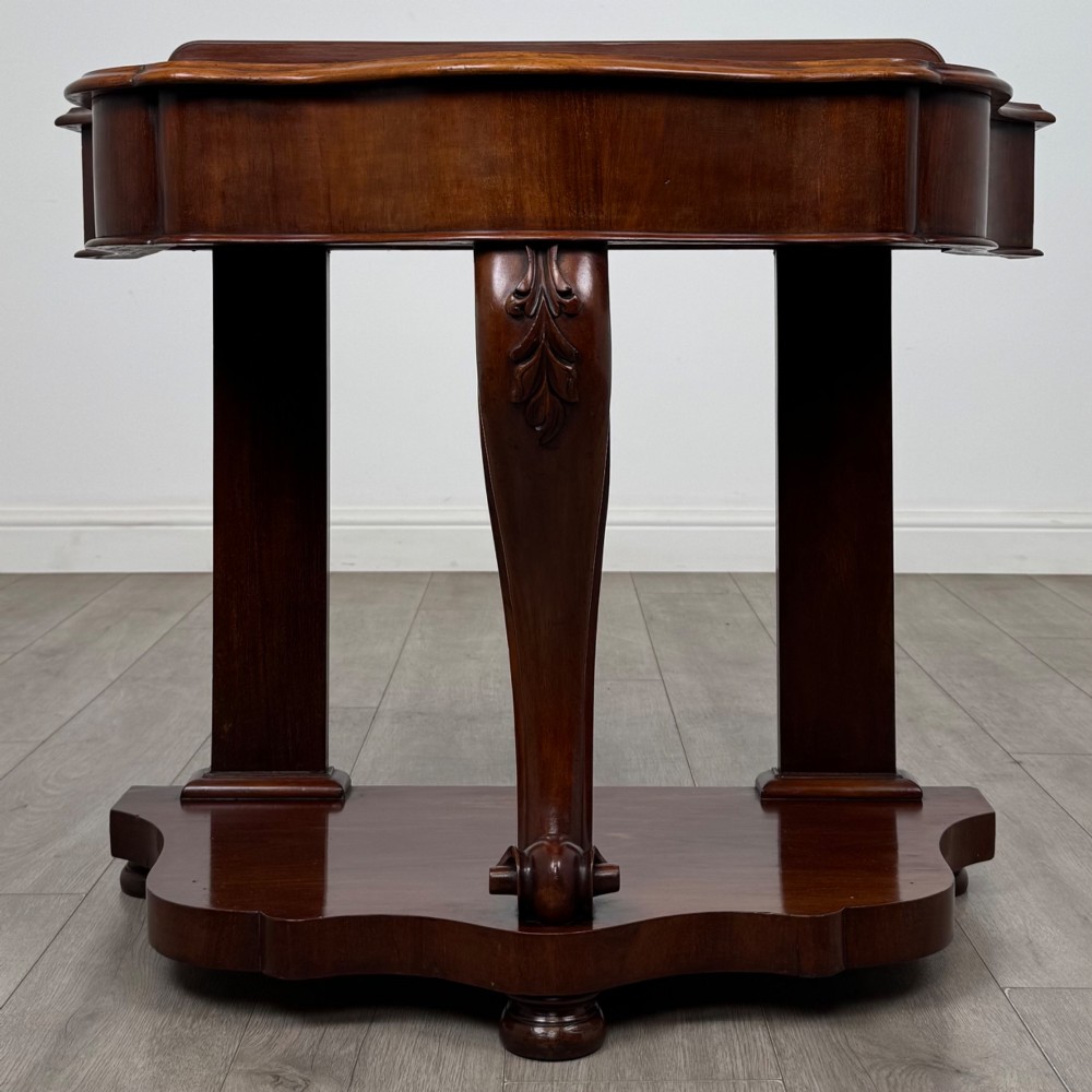 A 19th-century Victorian mahogany washstand featuring a carved central leg, shaped top, and contoured plinth base.