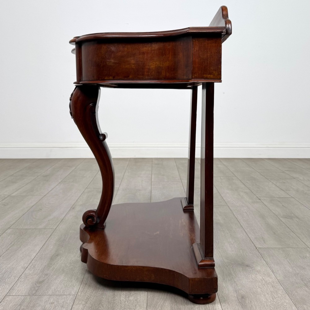 A 19th-century Victorian mahogany washstand featuring a carved central leg, shaped top, and contoured plinth base. View III