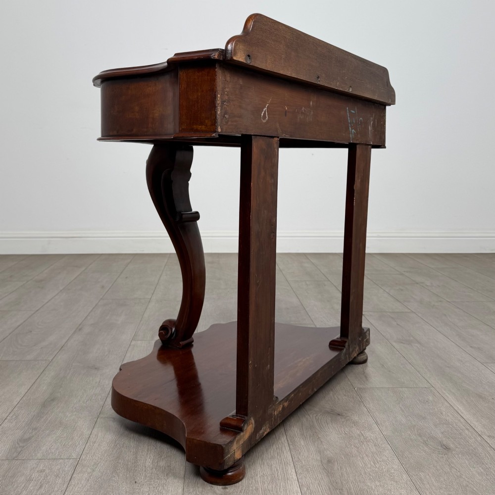 A 19th-century Victorian mahogany washstand featuring a carved central leg, shaped top, and contoured plinth base. View IV