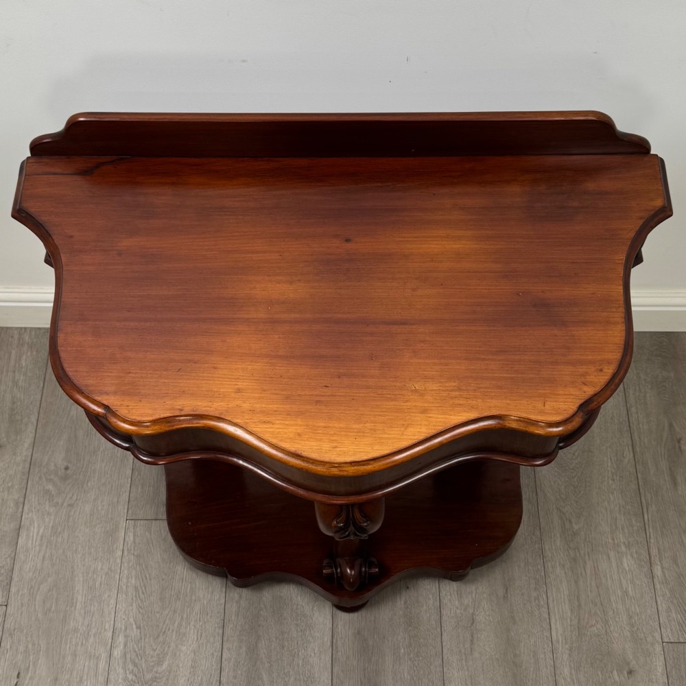 A 19th-century Victorian mahogany washstand featuring a carved central leg, shaped top, and contoured plinth base. View IX