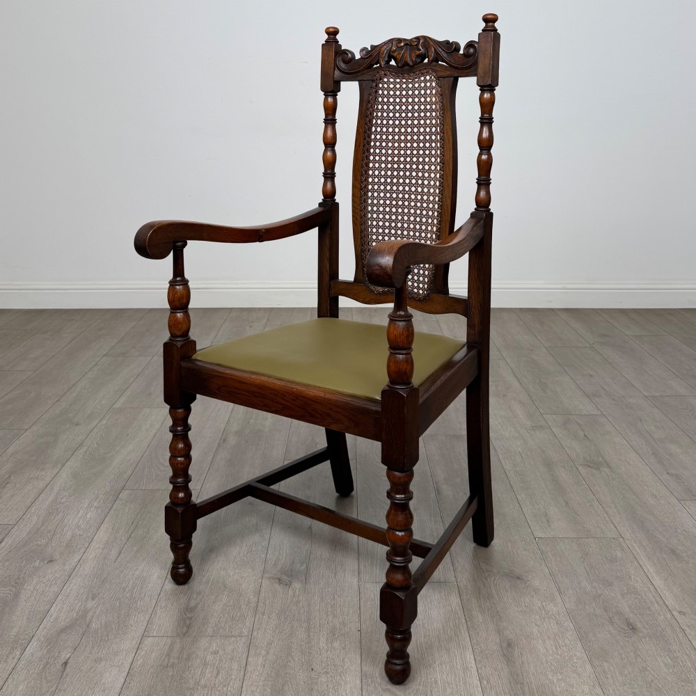 A set of six Victorian oak dining chairs featuring carved crest rails, cane backrest panels, turned legs, and green upholstered seats. View II