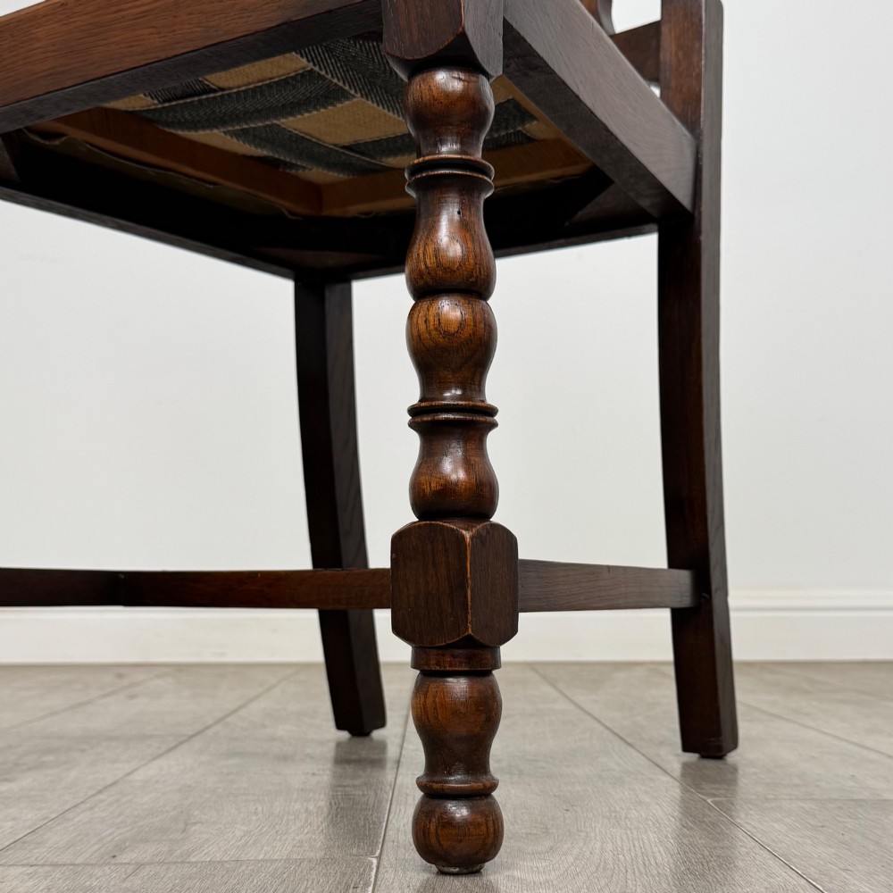 A set of six Victorian oak dining chairs featuring carved crest rails, cane backrest panels, turned legs, and green upholstered seats. View VII