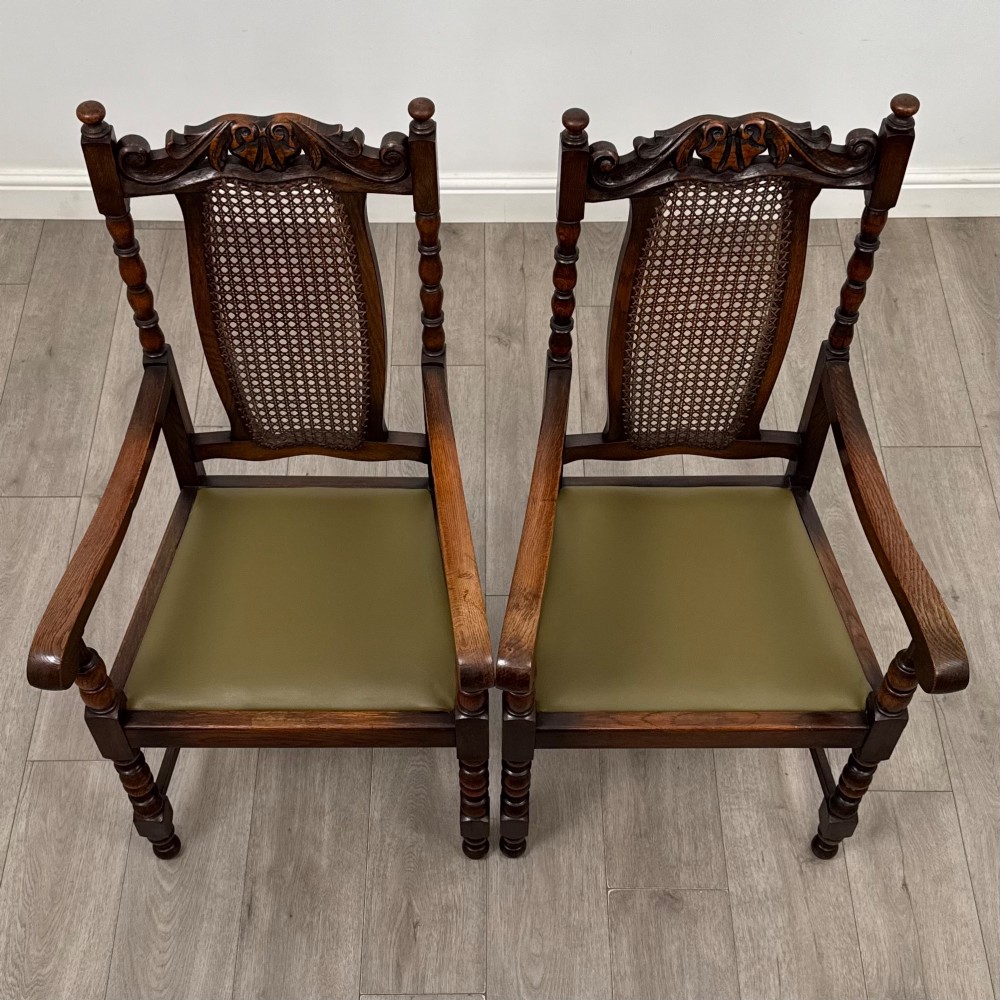 A set of six Victorian oak dining chairs featuring carved crest rails, cane backrest panels, turned legs, and green upholstered seats. View VIII