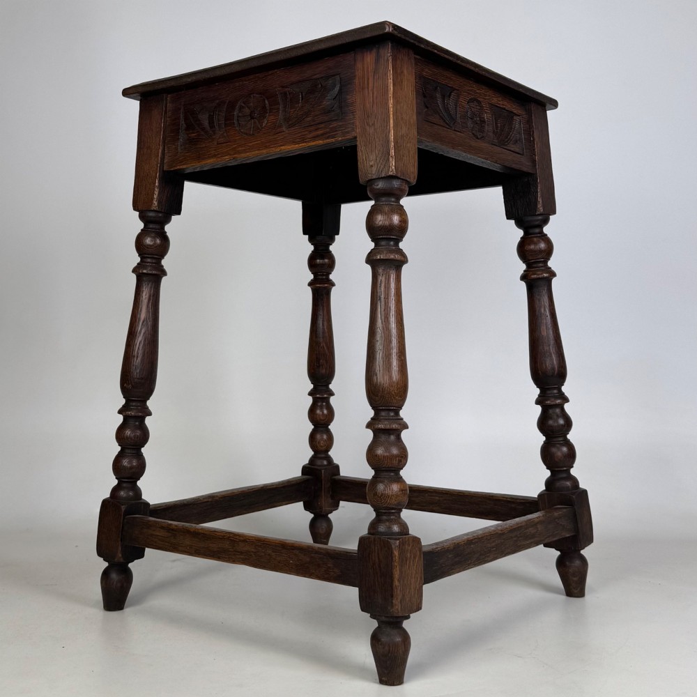 An antique dark oak side table featuring carved rosette apron details, turned legs, and lower stretchers. View IV