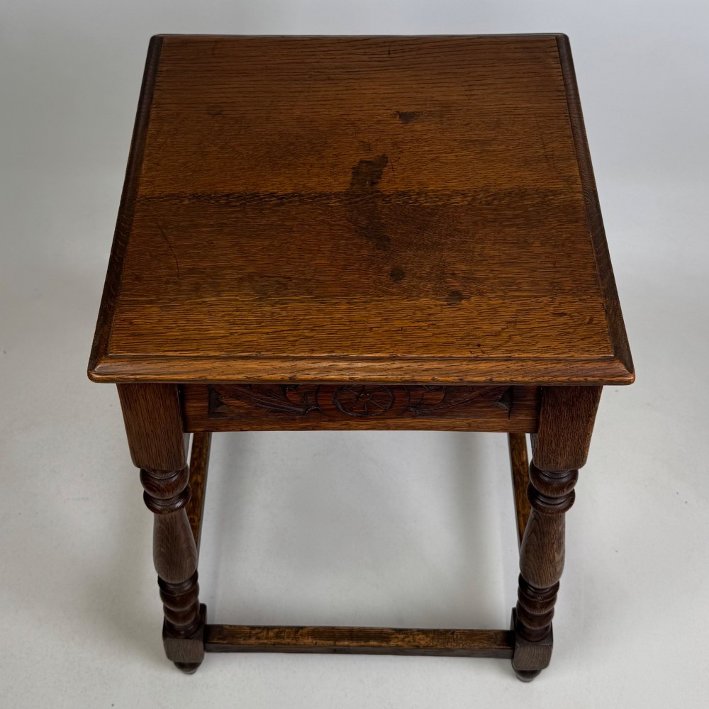 An antique dark oak side table featuring carved rosette apron details, turned legs, and lower stretchers. View IX