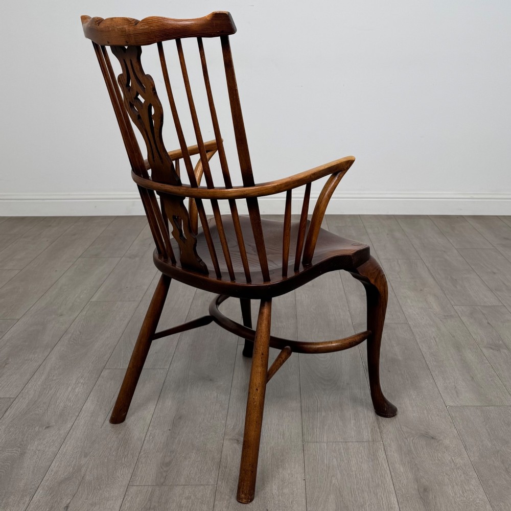 A pair of warm brown elm Windsor armchairs featuring shaped top rails, pierced back splats, spindle supports, shaped saddle seats, and front cabriole legs. View VI
