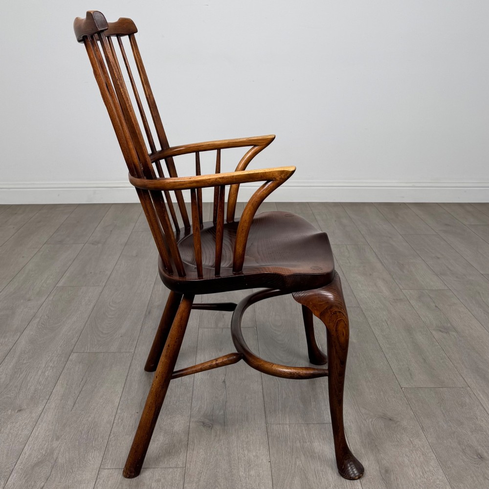 A pair of warm brown elm Windsor armchairs featuring shaped top rails, pierced back splats, spindle supports, shaped saddle seats, and front cabriole legs. View VII