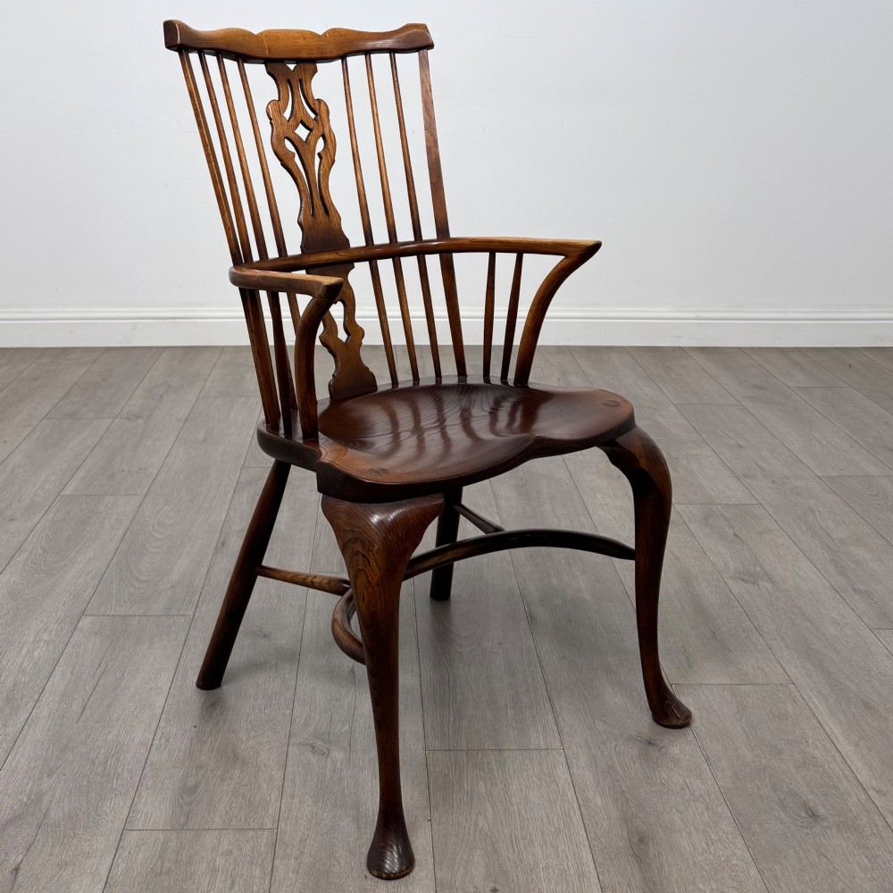 A pair of warm brown elm Windsor armchairs featuring shaped top rails, pierced back splats, spindle supports, shaped saddle seats, and front cabriole legs. View VIII