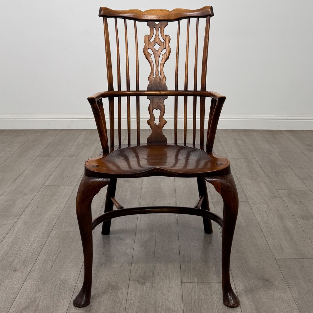 A pair of warm brown elm Windsor armchairs featuring shaped top rails, pierced back splats, spindle supports, shaped saddle seats, and front cabriole legs. View IX
