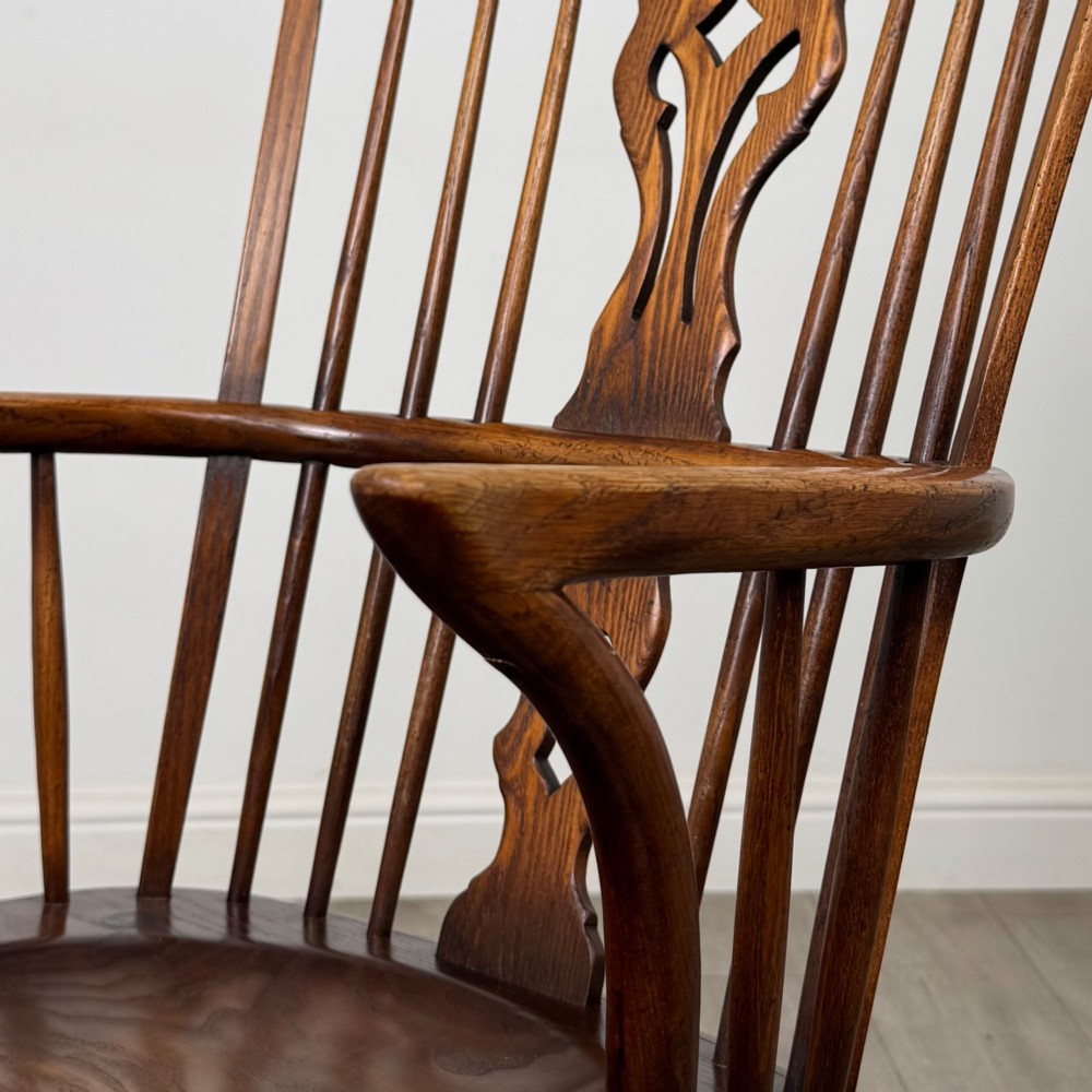 A pair of warm brown elm Windsor armchairs featuring shaped top rails, pierced back splats, spindle supports, shaped saddle seats, and front cabriole legs. View XII