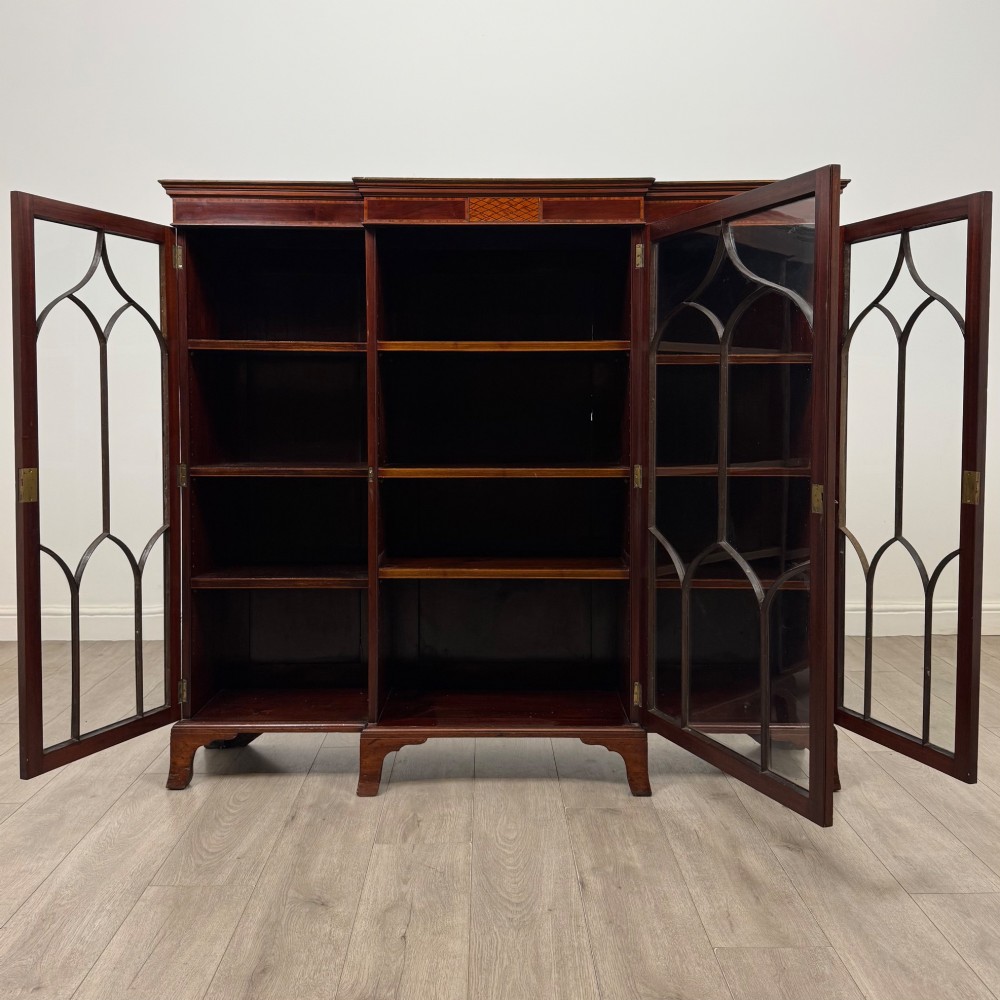 A Victorian mahogany breakfront display cabinet with three astragal glazed doors featuring gothic arch tracery and top frieze inlay. View II