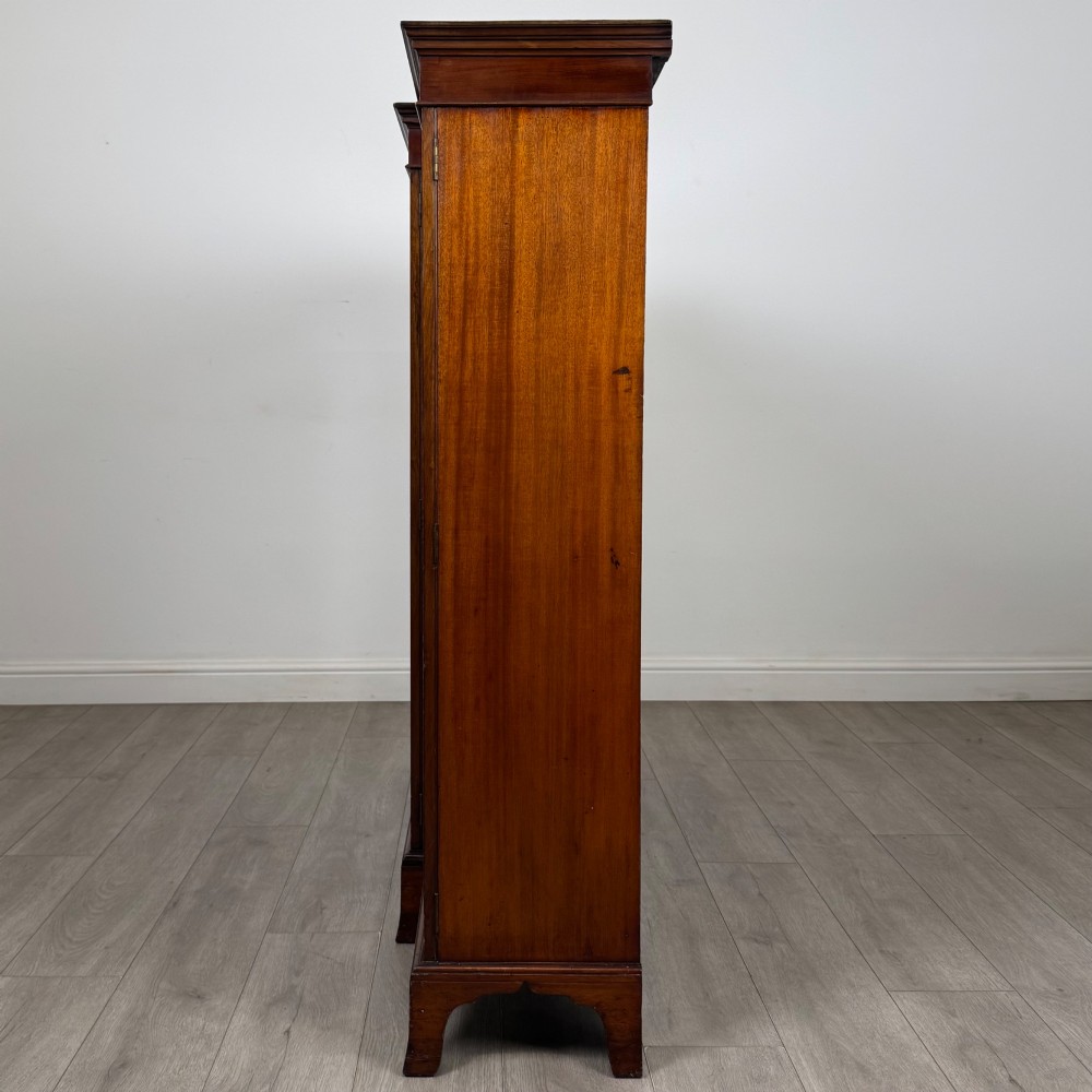 A Victorian mahogany breakfront display cabinet with three astragal glazed doors featuring gothic arch tracery and top frieze inlay. View IV