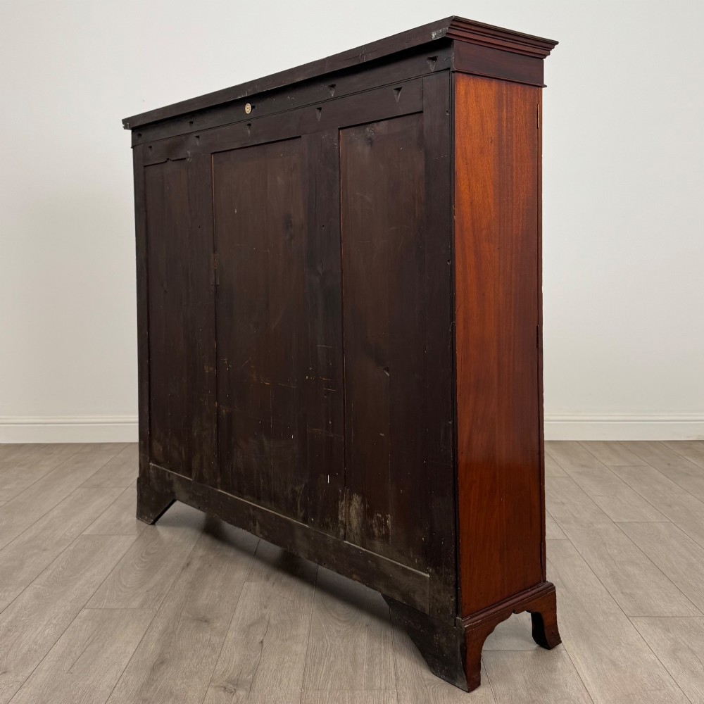 A Victorian mahogany breakfront display cabinet with three astragal glazed doors featuring gothic arch tracery and top frieze inlay. View VII
