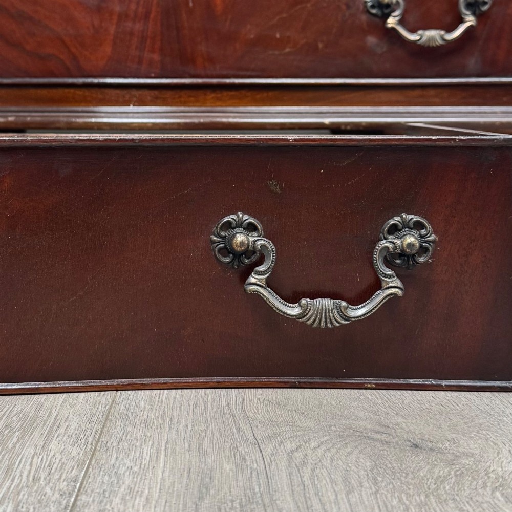 A mahogany serpentine-front chest of drawers featuring four graduated drawers with brass handles and bracket feet. View XII
