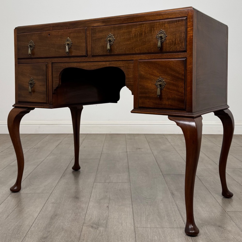 An Edwardian mahogany writing table featuring four drawers with ornamental brass drop handles, a central kneehole aperture, and four cabriole legs. View II