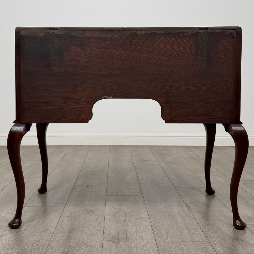 An Edwardian mahogany writing table featuring four drawers with ornamental brass drop handles, a central kneehole aperture, and four cabriole legs. View V