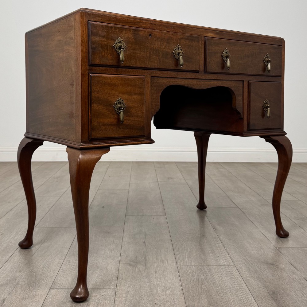 An Edwardian mahogany writing table featuring four drawers with ornamental brass drop handles, a central kneehole aperture, and four cabriole legs. View VIII