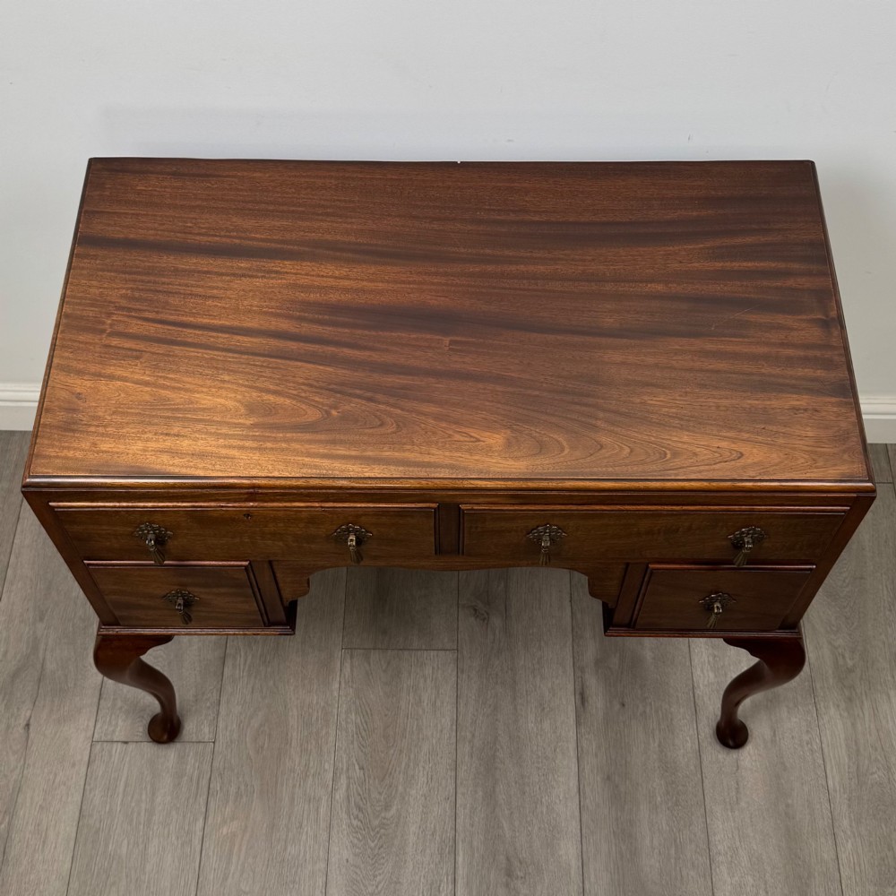 An Edwardian mahogany writing table featuring four drawers with ornamental brass drop handles, a central kneehole aperture, and four cabriole legs. View IX