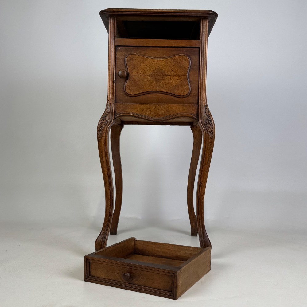 An antique French walnut bedside cabinet featuring high slender cabriole legs, a single drawer, and a carved wooden door with a marquetry panel. View XI