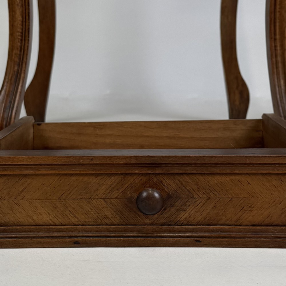 An antique French walnut bedside cabinet featuring high slender cabriole legs, a single drawer, and a carved wooden door with a marquetry panel. View XII