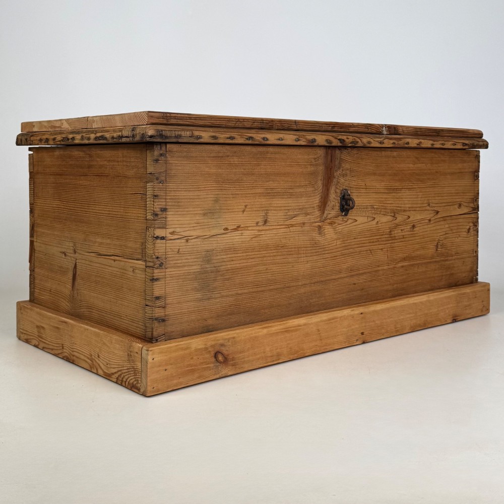 A nineteenth-century Victorian pine blanket box featuring a flat hinged lid, central iron keyhole escutcheon, visible corner joinery, and a solid plinth base. View VIII